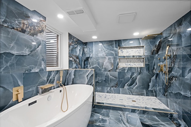 full bath featuring marble finish floor, tile walls, a soaking tub, visible vents, and walk in shower