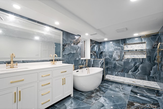 bathroom featuring double vanity, marble finish floor, a freestanding bath, and a sink