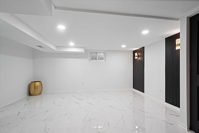 finished below grade area featuring recessed lighting, marble finish floor, visible vents, and baseboards