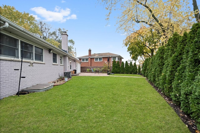 view of yard featuring central AC and a patio