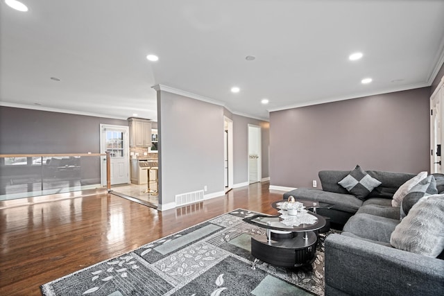 living room with recessed lighting, visible vents, baseboards, and wood finished floors