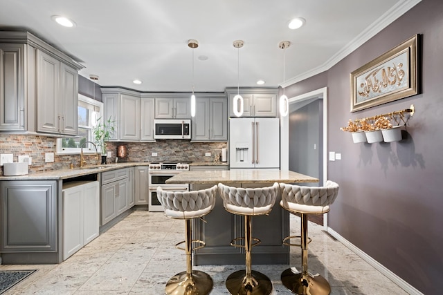 kitchen with light stone counters, high end appliances, decorative backsplash, and gray cabinetry