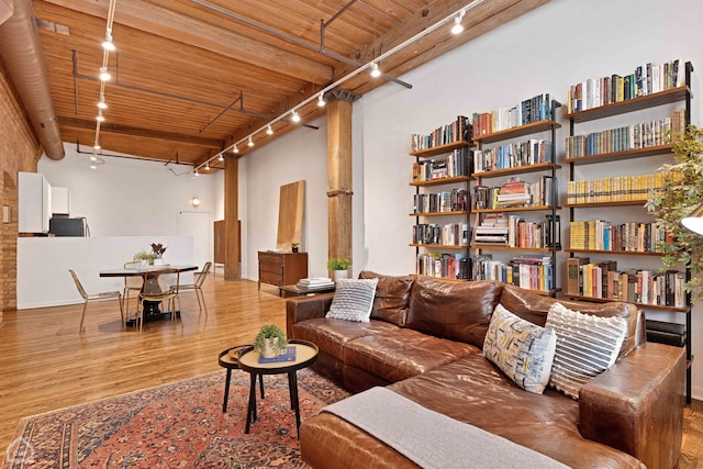 living room with rail lighting, wood ceiling, and wood finished floors