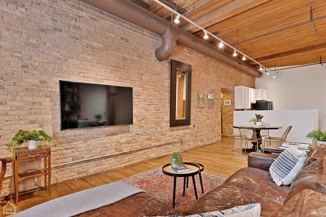 living room with brick wall and wood finished floors