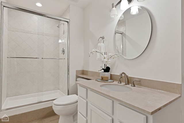 full bathroom featuring a stall shower, tile patterned flooring, vanity, and toilet