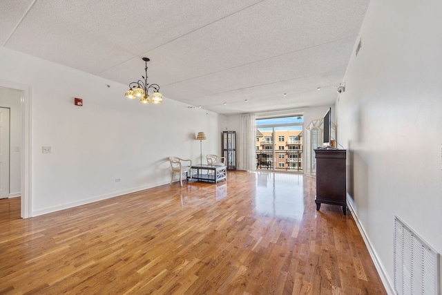 unfurnished room featuring wood finished floors, visible vents, and baseboards