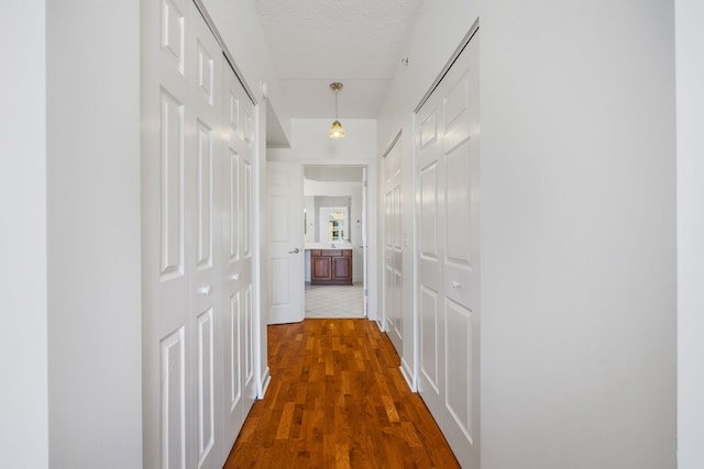 hall featuring dark wood-style floors and a textured ceiling