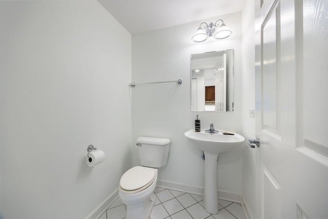 bathroom featuring tile patterned flooring, baseboards, a sink, and toilet