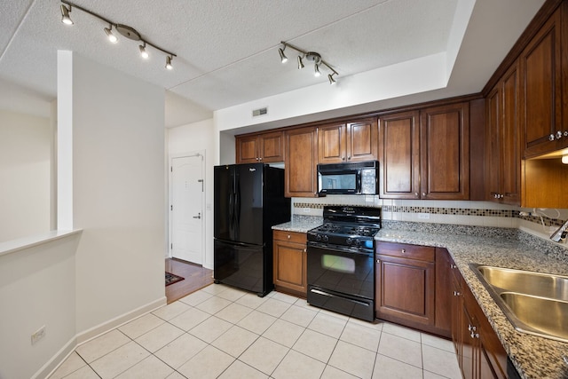 kitchen featuring light tile patterned floors, visible vents, backsplash, a sink, and black appliances