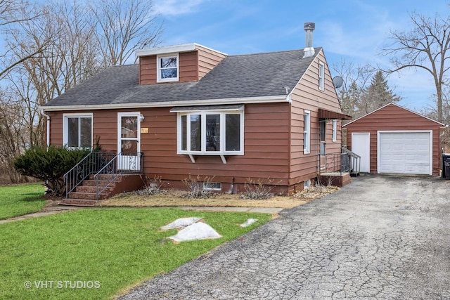 view of front of home featuring an outbuilding, roof with shingles, a detached garage, driveway, and a front lawn