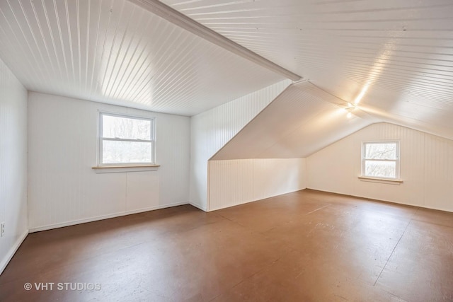 bonus room with finished concrete flooring and vaulted ceiling