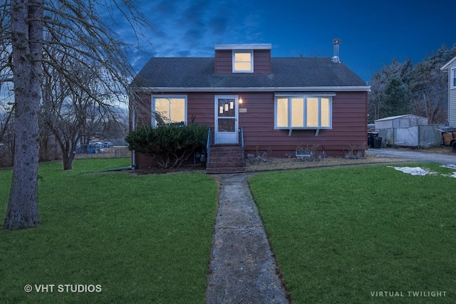 bungalow-style house featuring entry steps, a front lawn, and roof with shingles