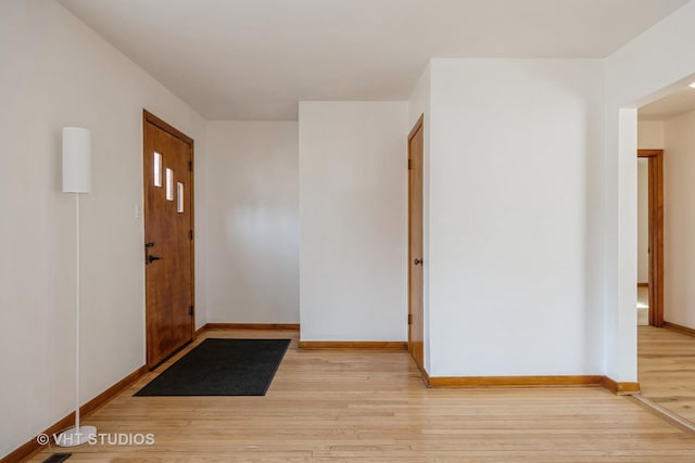 entrance foyer with baseboards and wood finished floors