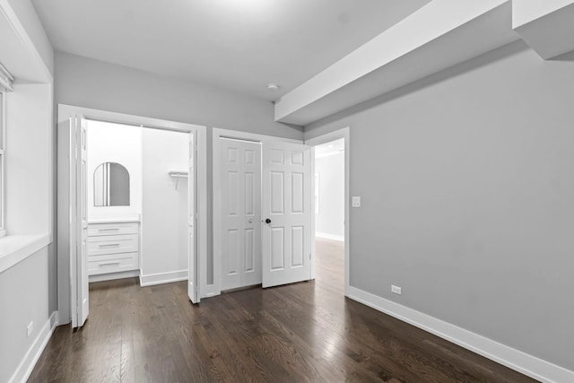 unfurnished bedroom featuring dark wood-style flooring and baseboards