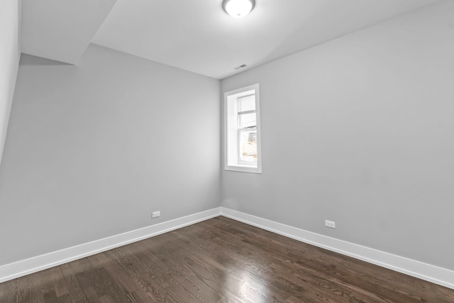 spare room with dark wood-style flooring and baseboards