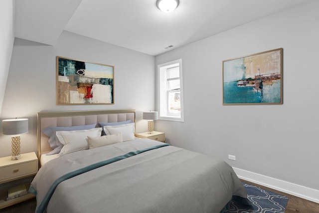 bedroom with dark wood-style flooring, visible vents, and baseboards