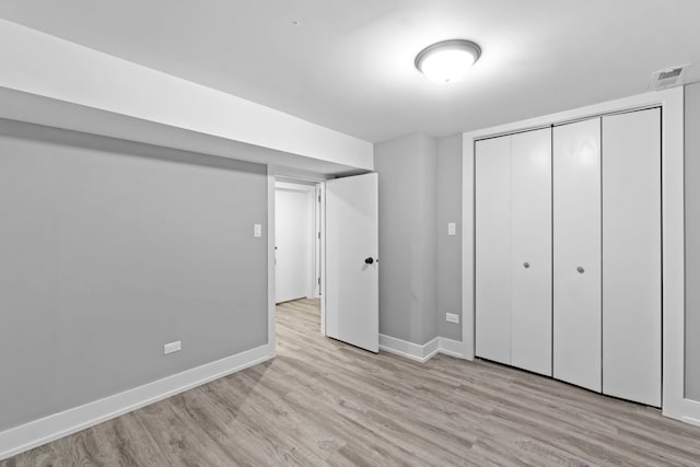 unfurnished bedroom featuring a closet, light wood-type flooring, visible vents, and baseboards