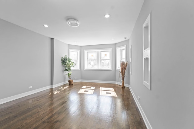 unfurnished room with recessed lighting, dark wood finished floors, and baseboards