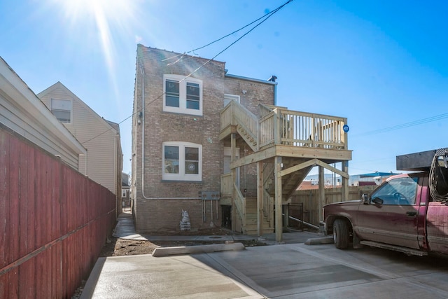 back of property featuring brick siding and fence