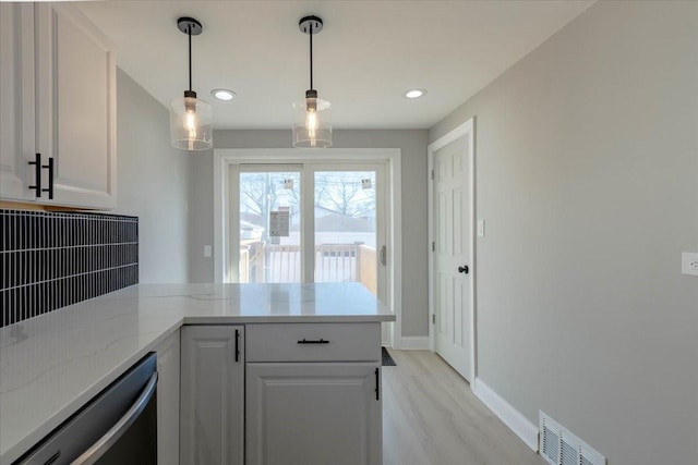 kitchen featuring a peninsula, decorative backsplash, visible vents, and white cabinetry