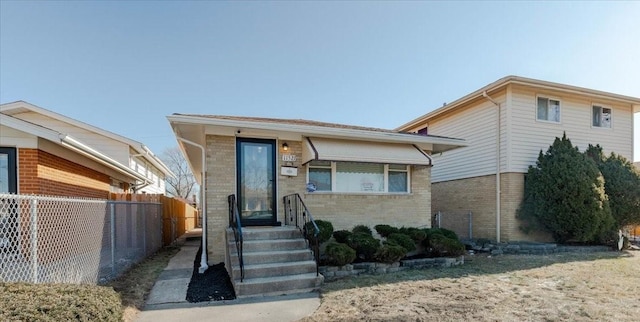 view of front facade featuring brick siding and fence