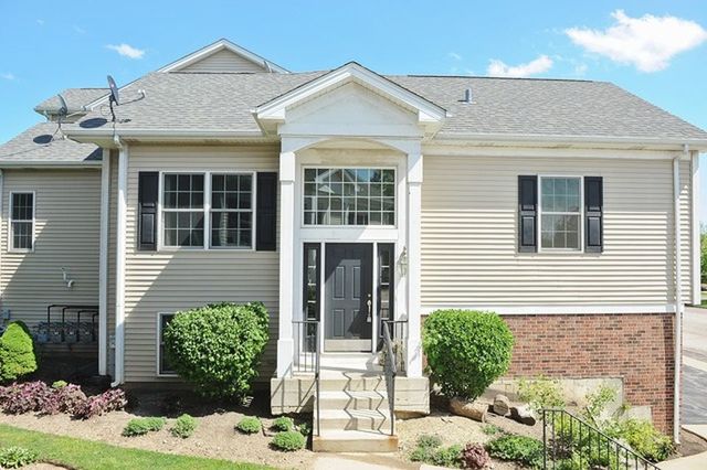 view of front facade featuring a shingled roof and brick siding