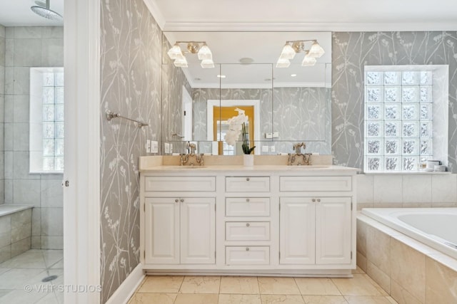 bathroom featuring double vanity, wallpapered walls, tiled tub, and a sink