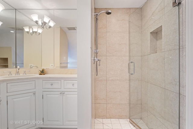 full bathroom featuring a shower stall, a chandelier, and vanity