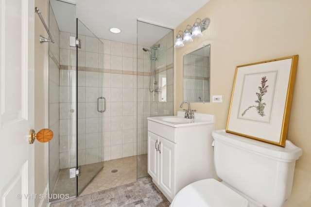 full bathroom featuring a shower stall, toilet, and vanity