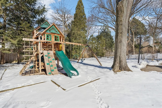 snow covered playground featuring playground community and fence