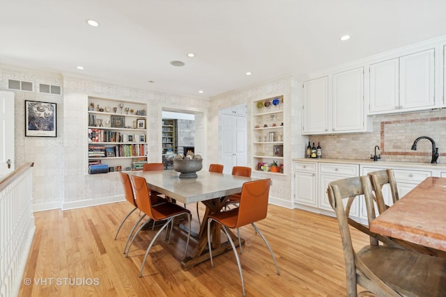 dining room featuring light wood finished floors, baseboards, and visible vents