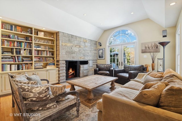 living room with french doors, a fireplace, recessed lighting, light wood-style floors, and vaulted ceiling