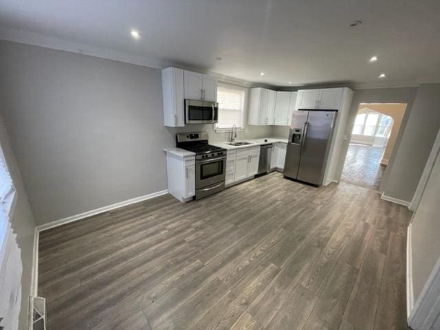 kitchen featuring stainless steel appliances, light countertops, white cabinets, and a sink