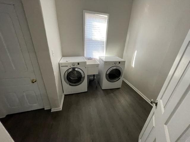 washroom featuring dark wood-style floors, a sink, separate washer and dryer, laundry area, and baseboards