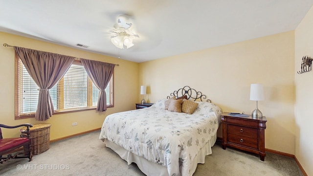 carpeted bedroom featuring a ceiling fan, visible vents, and baseboards