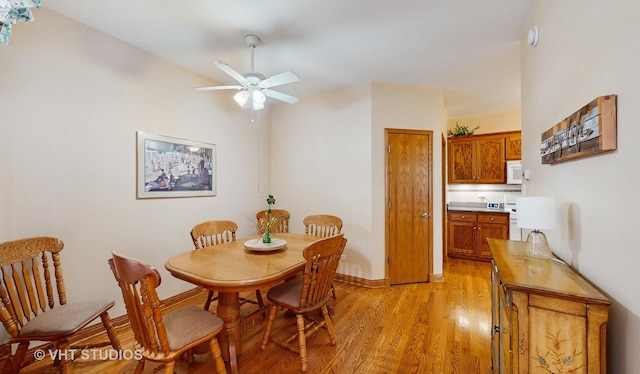 dining space with ceiling fan, baseboards, and light wood-style floors