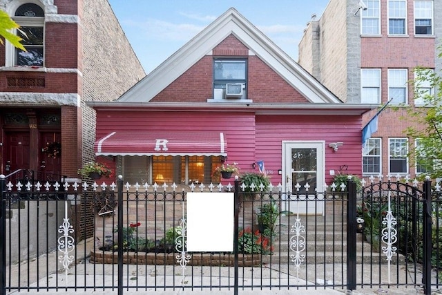 view of front of house with a fenced front yard, a gate, and brick siding