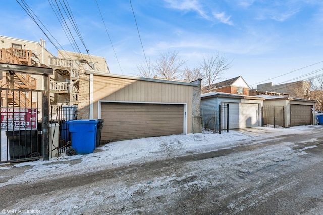 snow covered garage featuring fence