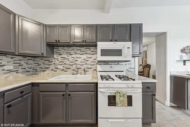 kitchen with white appliances, light tile patterned flooring, a sink, and decorative backsplash