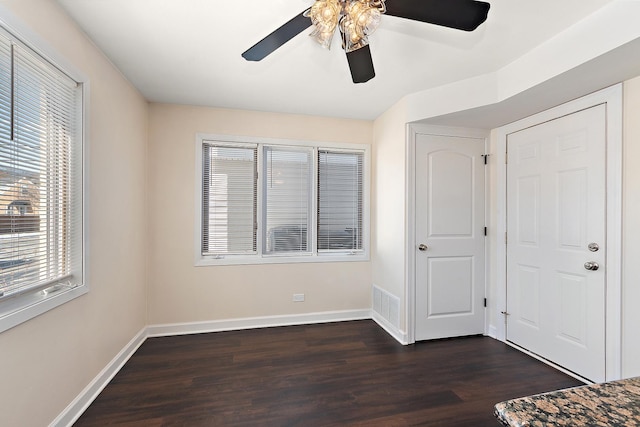 unfurnished bedroom with dark wood-style floors, baseboards, and a ceiling fan