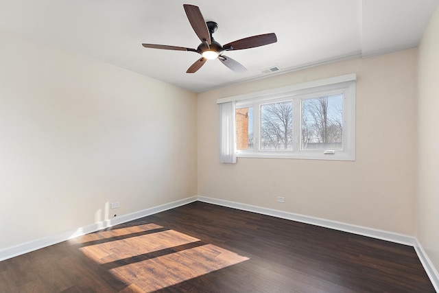 unfurnished room with dark wood-type flooring, a ceiling fan, visible vents, and baseboards