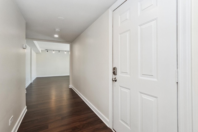 hallway featuring baseboards and dark wood-style flooring