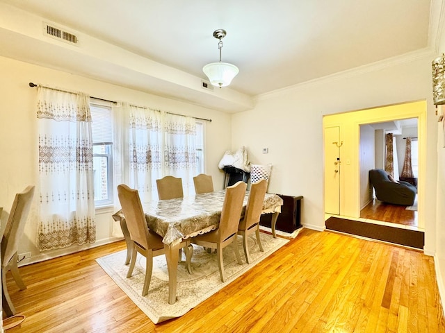 dining space featuring ornamental molding, visible vents, baseboards, and wood finished floors