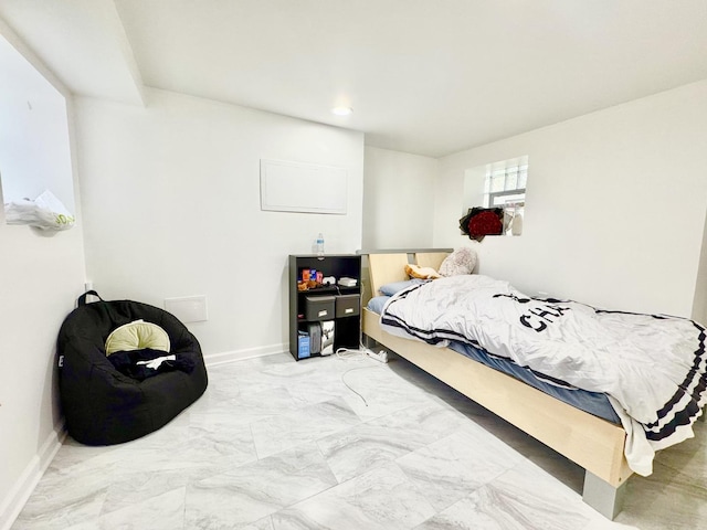 bedroom featuring marble finish floor and baseboards