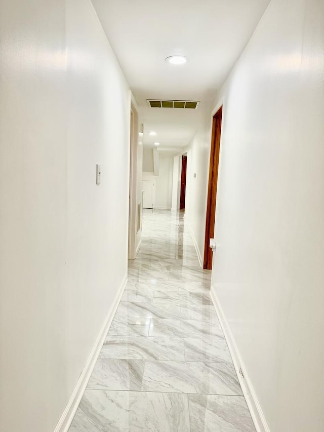 hall with marble finish floor, visible vents, and baseboards