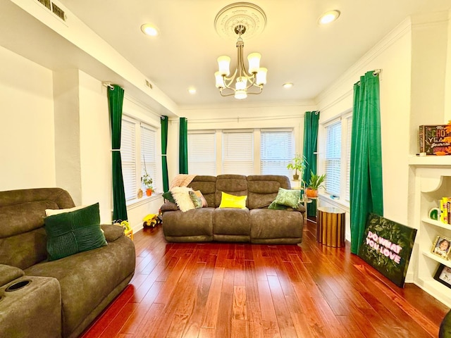 living room with dark wood-type flooring, recessed lighting, crown molding, and an inviting chandelier