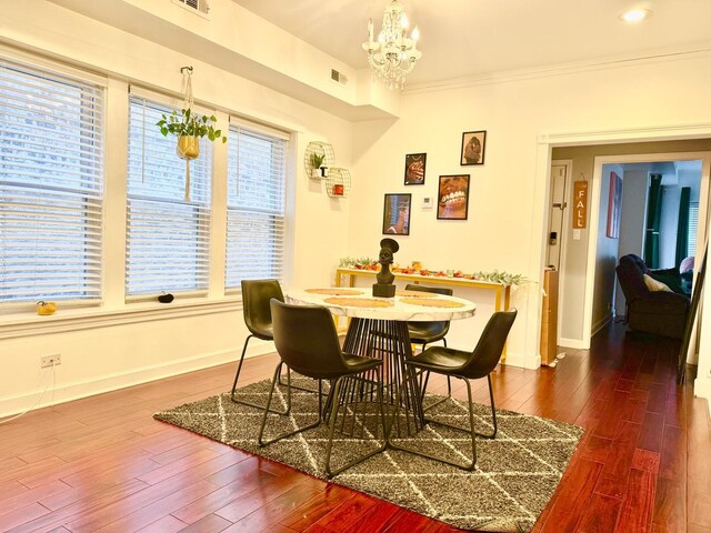 dining room with a notable chandelier, visible vents, baseboards, ornamental molding, and dark wood-style floors