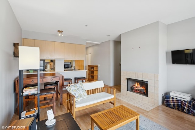 living area with light wood-type flooring and a fireplace