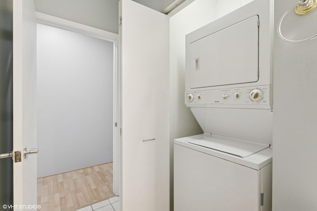 clothes washing area featuring stacked washer and dryer and laundry area