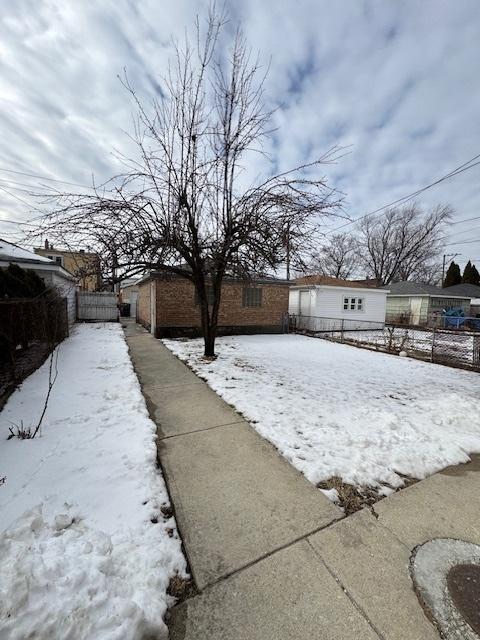 snowy yard featuring fence